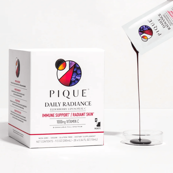 Box and sachet of Pique Daily Radiance elderberry supplement being poured into a clear dish.
