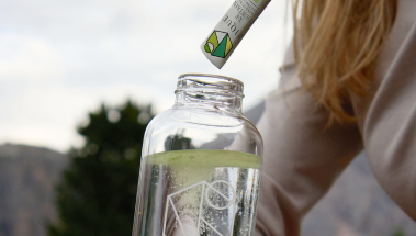 Stirring a serving of X·E Fountain into a bottle of cold water